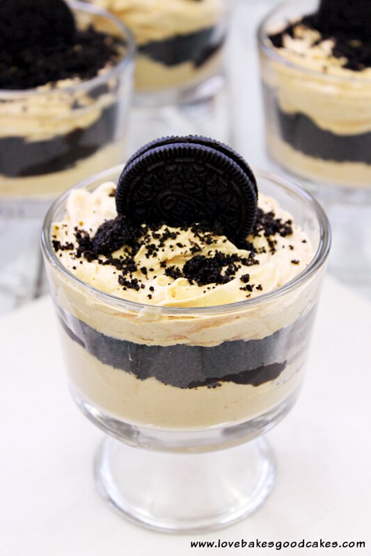 Pumpkin and Oreo Black Magic Parfaits in glass cups with OREO cookies on top.