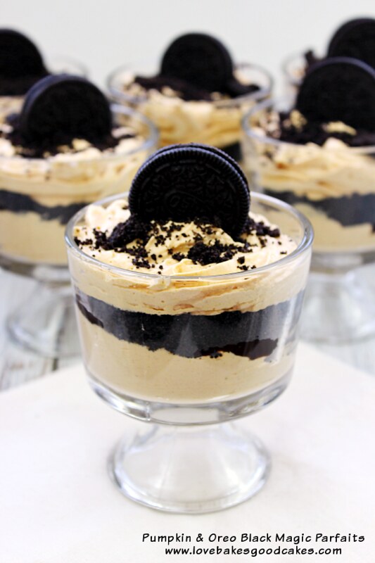 Pumpkin and Oreo Black Magic Parfaits in glass cups with an OREO cookie on top.