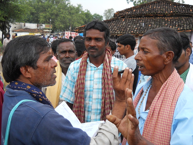 CGNet activist Gokaran Singh Verma teaching an Adivasi at a weekly haat in Jashpur district how to report through mobile.