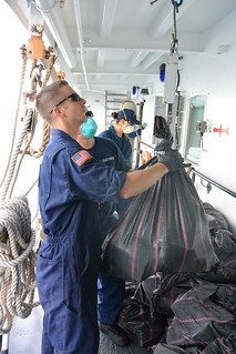 Chief Petty Officer James Koon weighs narcotics seized during a counter-drug patrol in the eastern Pacific Ocean off the coast of South and Central America aboard the Cutter Alert from Astoria, Ore., Sept. 27, 2014. The crew of Alert will return home Sunday following a 70-day deployment in the eastern Pacific Ocean where they interdicted three suspected vessels, detained 15 suspected smugglers, and seized more than 3,180 pounds of cocaine with a wholesale value of more than $48 million. (Coast Guard photo by Cutter Alert)