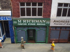 A model of a ground-floor terraced shopfront reading “M Richman / Furniture Storage Removals”.