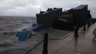 A 132-foot barge with containers being used as a Halloween attraction at Chicago's Navy Pier is battered by strong winds and heavy waves Oct. 31, 2014. Several of the containers were either partially or completely submerged after the barge broke from its mooring. (U.S. Coast Guard photo by Lt. Laura Gould.)